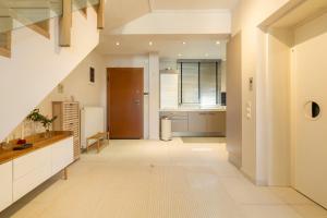 a large kitchen with white floors and a hallway at Something different in Chalkida in Chalkida