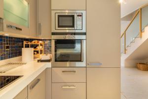 a kitchen with white cabinets and a microwave at Something different in Chalkida in Chalkida +38 photos
