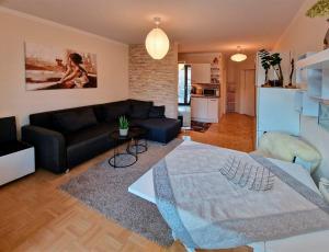 een woonkamer met een zwarte bank en een tafel bij Ferienwohnung Arlett in Dresden