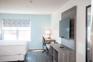 a hotel room with a bed and a television at THE NEST in Greenfield