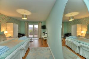 a bedroom with two beds and a mirror at Aspen Lodge in Oban