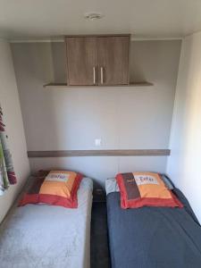 a small room with two beds and a cabinet at Mobil home confort 6 personnes in Saint-Chéron