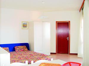 a bedroom with a bed and a red door at Flat in Lignano Sabbiadoro in Lignano Sabbiadoro