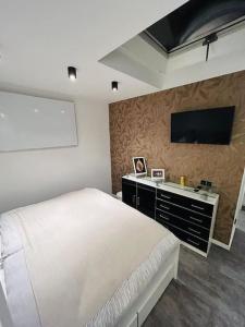 a bedroom with a bed and a flat screen tv at Bezauberndes Apartment im Herzen von Nieukerk. in Kerken