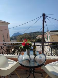 een tafel met twee glazen wijn op een balkon bij San Vlassis Area Apartment in Lákones