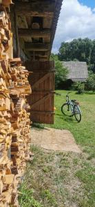 un mucchio di legno sul lato di un edificio accanto a una bicicletta di Dom Na Wsi u Ani a Koszele