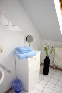 Baño blanco con lavabo y espejo en Ferienwohnung Südhoff, en Horumersiel