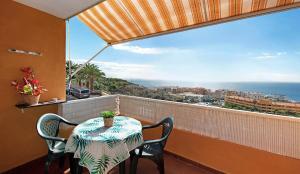 a table and chairs on a balcony with a view of the ocean at Apartamento en Los Gigantes, Tenerife in Puerto de Santiago