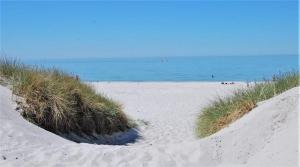 a beach with sand dunes and the ocean in the background at Ferienwohnung Karnitz im Herzen von Rügen in Karnitz +28 photos