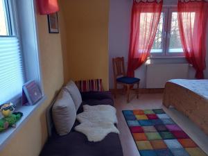 um quarto com um sofá, uma cama e janelas em Ferienwohnung Rathke em Sorge