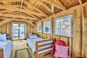 a room with two beds and two windows at Henderson Harbor Cottage with Lake Access! in Sackets Harbor