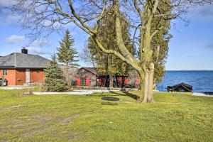 un árbol en el césped delante de una casa en Henderson Harbor Cottage with Lake Access!, en Sackets Harbor