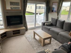 a living room with a couch and a tv at The Sherbourne in Selsey