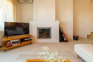 a living room with a fireplace and a flat screen tv at Something different in Chalkida in Chalkida