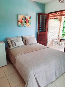 a bedroom with a large bed with a blue wall at Pousada dos Anjos Paracuru in Paracuru