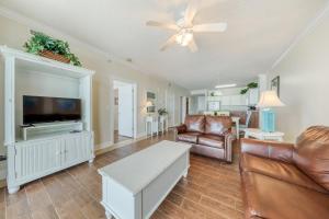 a living room with a couch and a flat screen tv at Ocean Villa 406 in Panama City Beach