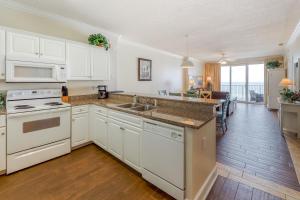a kitchen with white cabinets and a counter top at Ocean Villa 406 in Panama City Beach