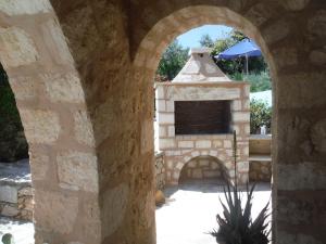 un arco de piedra con chimenea en un patio en Villa Amalthiea, en Arménoi