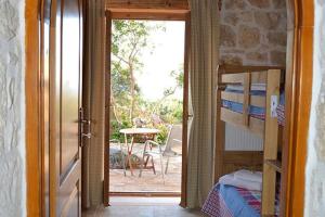 een slaapkamer met een deur naar een patio met een tafel bij Villa Amalthiea in Arménoi