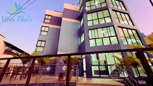 ポルト・デ・ガリーニャスにある"Vivendo no Paraíso" - Flat C/Suíte no Centroの窓とヤシの木が目の前にそびえる高層ビル