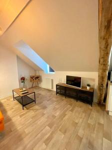 - un salon avec une télévision et du parquet dans l'établissement Appartement Cosy Hyper centre WIFI, à Rodez