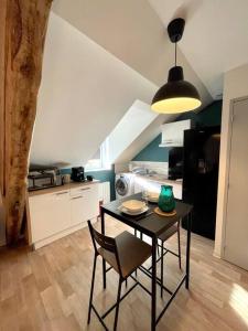 - une cuisine avec une table et une chaise dans la chambre dans l'établissement Appartement Cosy Hyper centre WIFI, à Rodez