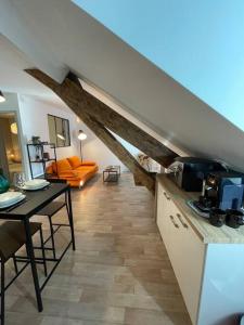 Il comprend une cuisine et un salon avec une table. dans l'établissement Appartement Cosy Hyper centre WIFI, à Rodez