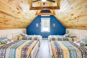 three beds in a room with blue walls and wooden ceilings at Maine Retreat with Balcony 5 Mi to Lakes in Harrison