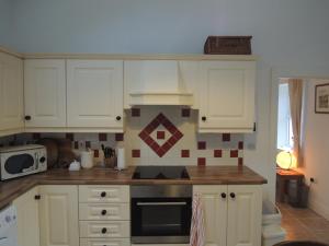 a kitchen with white cabinets and a stove top oven at Sally's Garden in Warrenpoint