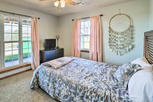 een slaapkamer met een bed en 2 ramen bij Incredible Log Home 1 Mile From Lake Tenkiller in Vian