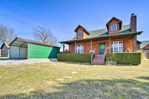 een huis met een groene garage en een houten huis bij Incredible Log Home 1 Mile From Lake Tenkiller in Vian