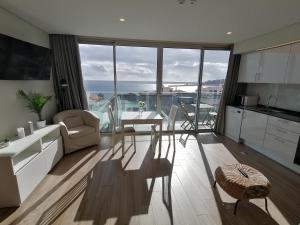 Apartments Madeira Barreirinha في فونشال: غرفة معيشة مع أريكة وطاولة ومطبخ
