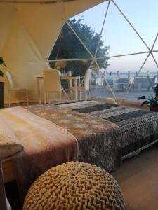 uma tenda com 2 camas, uma mesa e cadeiras em beautiful located dome em Wapnica