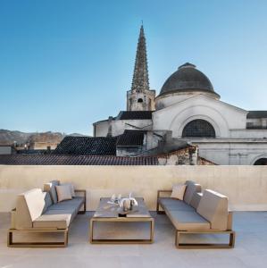 een patio met 2 stoelen en een tafel en een gebouw bij Hôtel de Tourrel, Saint Rémy de Provence, a Member of Design Hotels in Saint-Rémy-de-Provence