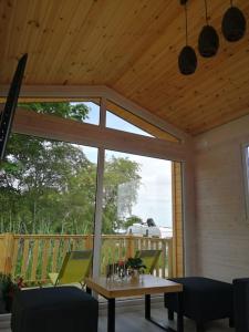a screened in porch with a table and chairs at Tiny beach house heated and airconditioned in Wapnica