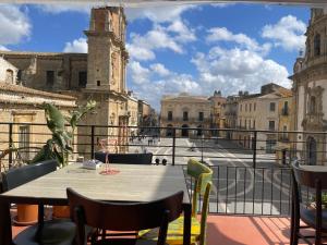 una mesa en un balcón con vistas a la ciudad en Casa Vacirca, en Niscemi