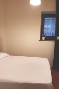 - une chambre avec un lit blanc et une fenêtre dans l'établissement Casa&Cantina, à Senise
