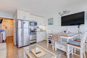 uma cozinha com um frigorífico de aço inoxidável e uma mesa em Harbour Beach Resort 611 em Daytona Beach