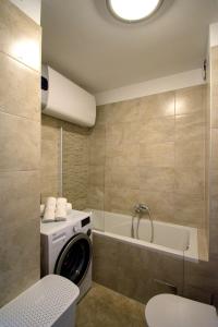 a bathroom with a washing machine and a tub at Apartment Nikola in Split