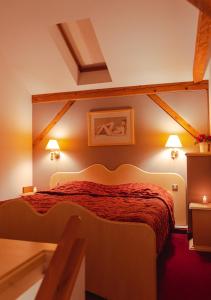 a bedroom with a bed with red sheets and two lamps at Hotel & Restaurant Se-Mi in Veliko Trgovišće +43 photos