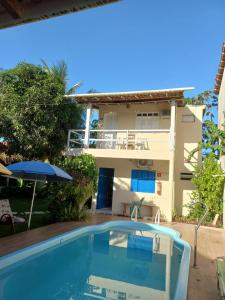 Villa con piscina frente a una casa en Pousada Cajueiro en Itaúnas