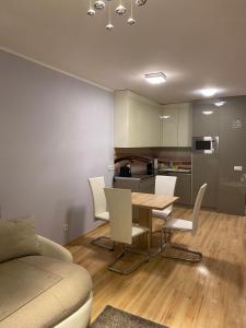 een keuken en eetkamer met een tafel en stoelen bij Belu Apartman in Balatonlelle