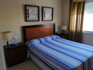a bedroom with a bed and two lamps and a window at Inviting apartment in Torremolinos with shared pool in Torremolinos