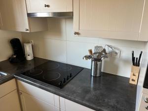 a kitchen counter with a stove top in a kitchen at Vakantiehuisje aan zee vlakbij Plopsaland en het strand - Casa Memphis in De Panne