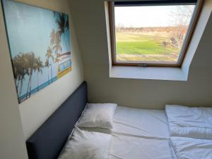 un lit dans une chambre avec une fenêtre dans l'établissement Vakantiehuisje aan zee vlakbij Plopsaland en het strand - Casa Memphis, à La Panne 26 autres photos