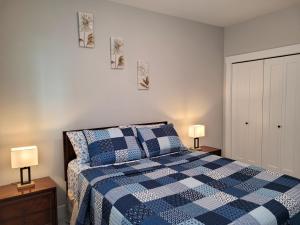 a bedroom with a blue and white bed and two lamps at Feel like Home! in Langford