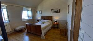 a small bedroom with a bed and two windows at L'ESTRAN in Saint-Valery-sur-Somme