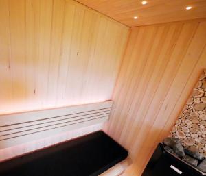 een bankje in een sauna met een houten muur bij Berghotel Zollersteighof in Albstadt