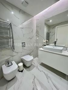 ein weißes Bad mit einem WC und einem Waschbecken in der Unterkunft Prime Lux Albufeira in Albufeira