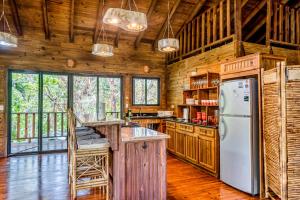 a kitchen with wooden walls and a refrigerator at Guapil #10 in Dominical